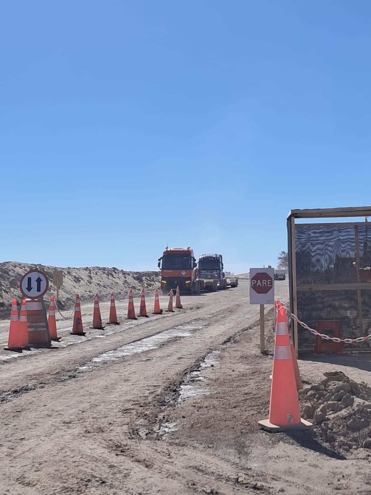 Truck convoy approaching a checkpoint with stop signage