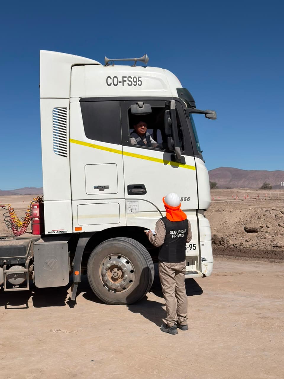 Guard logging a truck's entry at a mining job site
