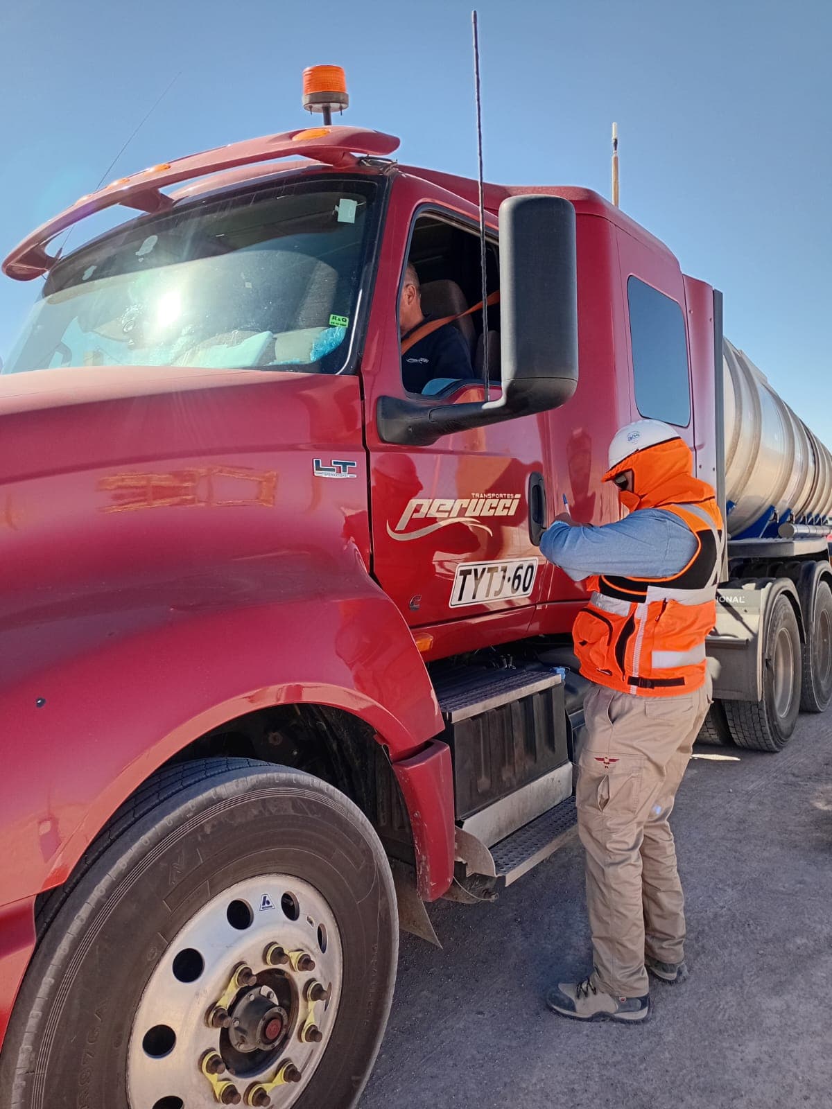 Guard controlling a tanker truck at a job site access point